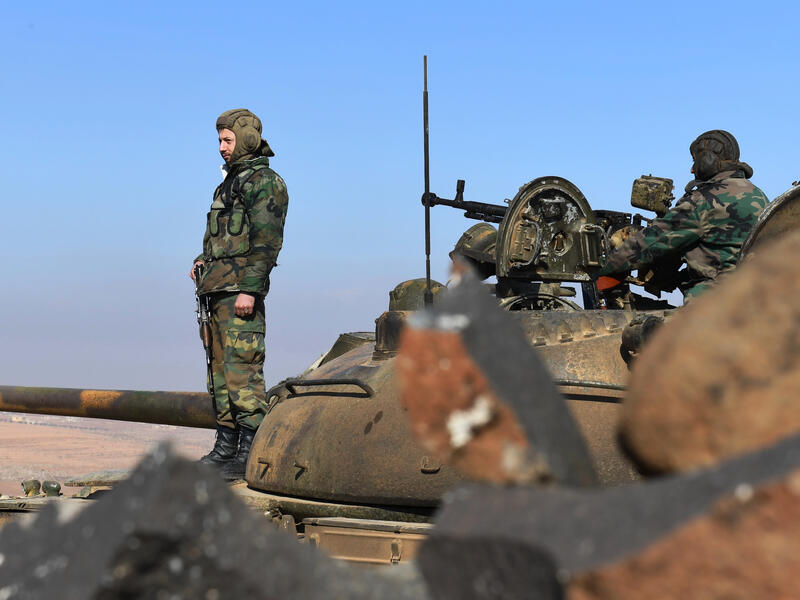 Members of the Syrian government forces stand on a tank in Jabal al-Hass in the southern part of Aleppo province as they advance towards the Abu Duhur military airport in the ongoing offensive against opposition fighters on January 14, 2018. Russia-backed regime troops are aiming to reach the Abu Duhur base as part of a weeks-long assault against Hayat Tahrir al-Sham (HTS), which is dominated by Al-Qaeda's former Syria affiliate. 