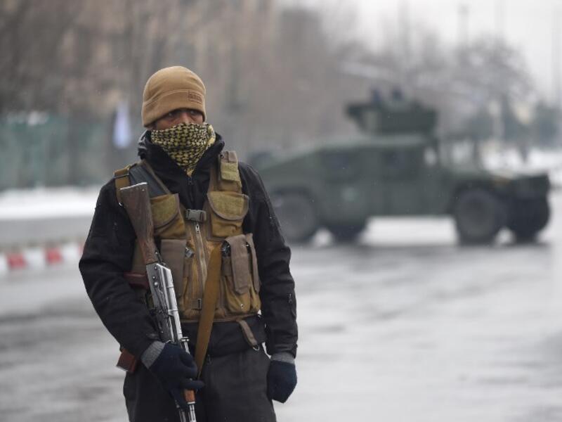 A member of an Afghan security detail guards the site of an ongoing attack near the Marshal Fahim Military Academy base in Kabul on Jan. 29, 2018 (WAKIL KOHSAR / AFP)
