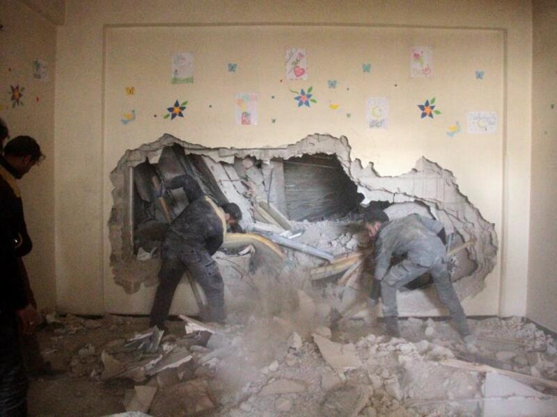 Syrian men look for survivors amid the rubble following reported air strikes on the rebel-held besieged town of Douma in the eastern Ghouta region, on the outskirts of the capital Damascus, on Feb. 6, 2018 (Hamza Al-Ajweh / AFP)