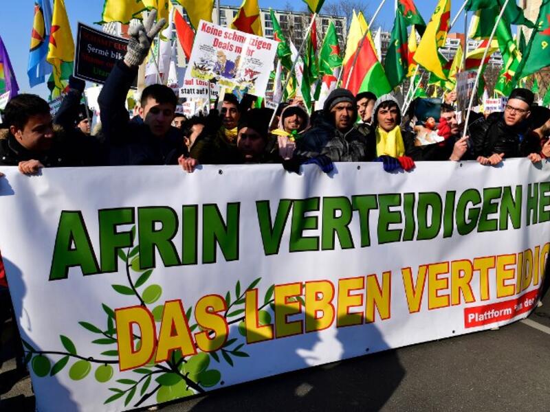 Protesters hold a giant banner reading "To defend Afrin means to defend life" during a demonstration of Kurdish groups to protest against Turkey's offensive against Kurds in Syria's Afrin region, on Mar. 3, 2018 in Berlin. 
(John MACDOUGALL / AFP)