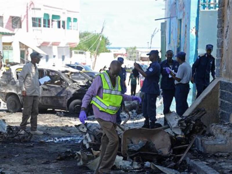 Somali soldiers and investigators work at the site of an explosion outside a restaurant in Mogadishu on April 9, 2016 (AFP)