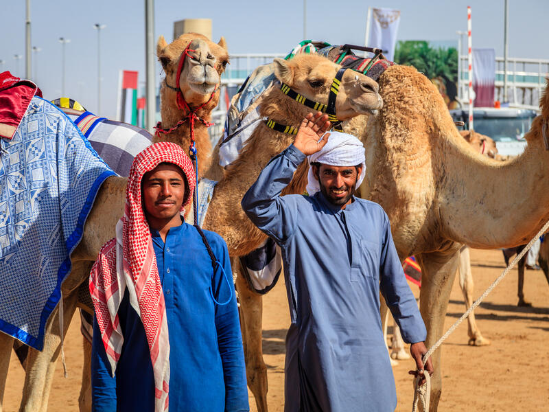 With their handlers at the Dubai Camel Racing Club (Shutterstock/File Photo) 