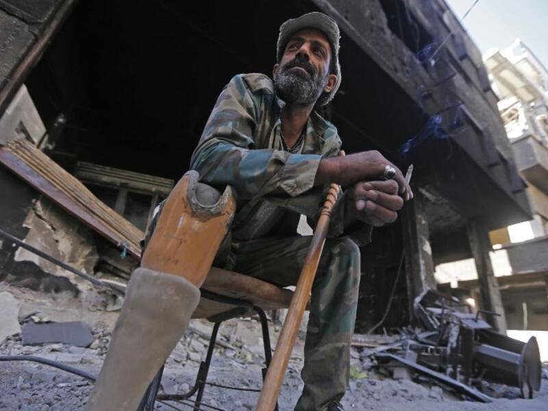 A man sits in a street near destroyed buildings in the Palestinian camp of Yarmuk southern Damascus on November 1, 2018. 
LOUAI BESHARA / AFP