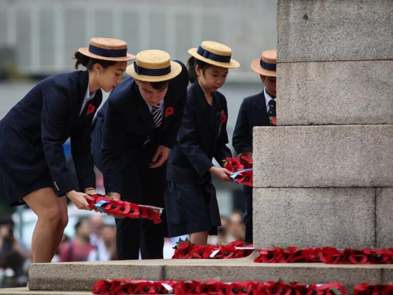 School children lay wreaths during a Remembrance Day ceremony honouring members of the armed forces who died in the line of duty at the Cenotaph marking the 100th anniversary of the end of World War I in Hong Kong on November 11, 2018. 
VIVEK PRAKASH / AFP