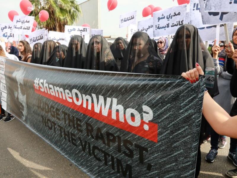 Activists hold banners against sexual assaults during the 16th edition of the Beirut Marathon on November 11, 2018. 
ANWAR AMRO / AFP