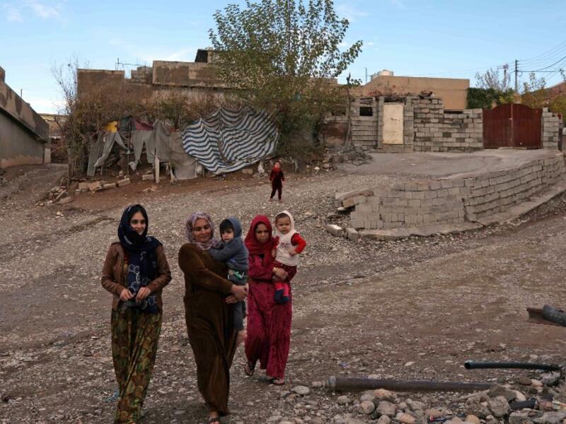 Women carry children as they walk in Sharboty Saghira, a small village east of regional capital Arbil.
SAFIN HAMED / AFP