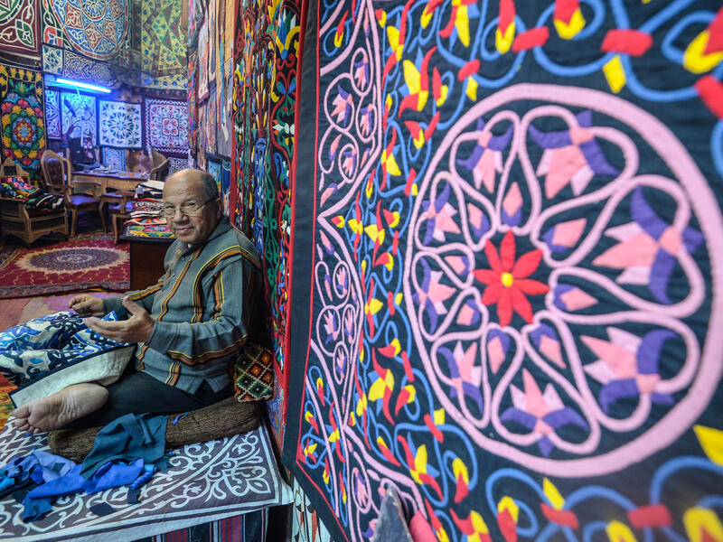 An Egyptian craftsman gestures as he sits while working on a tapestry in his shop in Khayamiya Street, or the Street of Tent-makers, in the old city of the Egyptian capital Cairo 
Mohamed el-Shahed / AFP