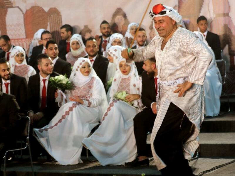 A man dressed in traditional Palestinian clothing dances during a mass wedding ceremony in the Lebanese fishing town of Rmaile, south of the capital Beirut
Mahmoud ZAYYAT / AFP