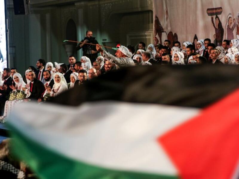 A man dressed in traditional Palestinian clothing dances during a mass wedding ceremony for 150 Palestinian couples and 50 other Lebanese couples, organised by PLO
Mahmoud ZAYYAT / AFP