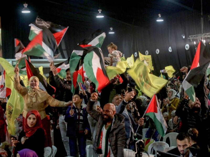 People wave flags of Palestine and Fatah as they attend a mass wedding ceremony 
Mahmoud ZAYYAT / AFP