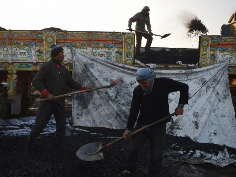 In this picture taken on January 8, 2019, Afghan labourers work at a coal yard amid heavy smog conditions in the outskirts of Kabul. 
WAKIL KOHSAR / AFP