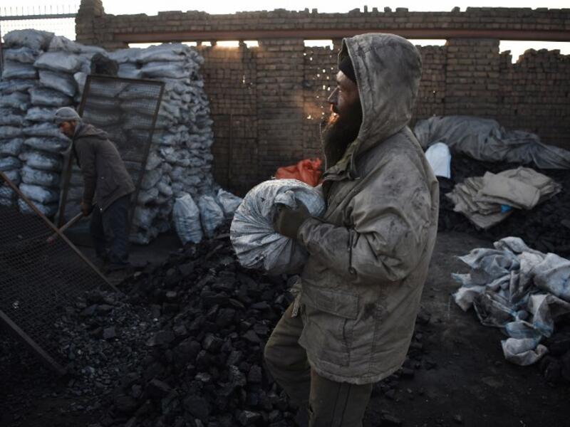 In this picture, Afghan day labourers work at a coal yard amid heavy smog conditions in the outskirts of Kabul. 
WAKIL KOHSAR / AFP