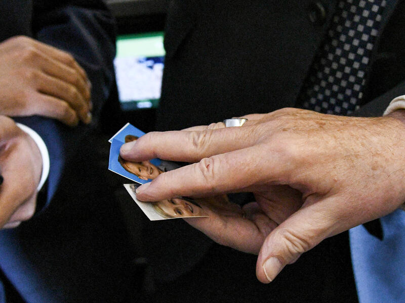 Pope Francis blesses photographs of children as he welcomes journalists aboard his plane after take-off on his way to Abu Dhabi, on February 3, 2019. 
Vincenzo PINTO / AFP