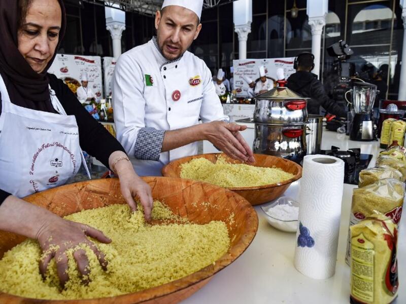 An Algerian chef directs a woman as they prepare couscous during the 2nd edition of the International Couscous Festival at the Moufdi Zakaria Palace of Culture in Algeria
RYAD KRAMDI / AFP