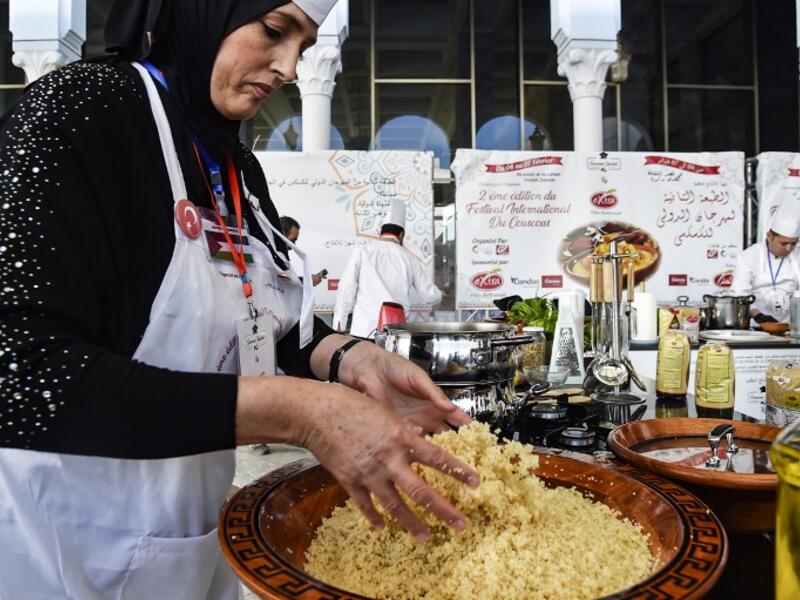 A woman prepares couscous during the 2nd edition of the International Couscous Festival at the Moufdi Zakaria Palace of Culture in Algeria
RYAD KRAMDI / AFP