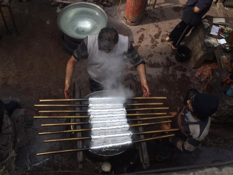 Pakistani workers dye fabric threads at a factory in Lahore 
ARIF ALI / AFP