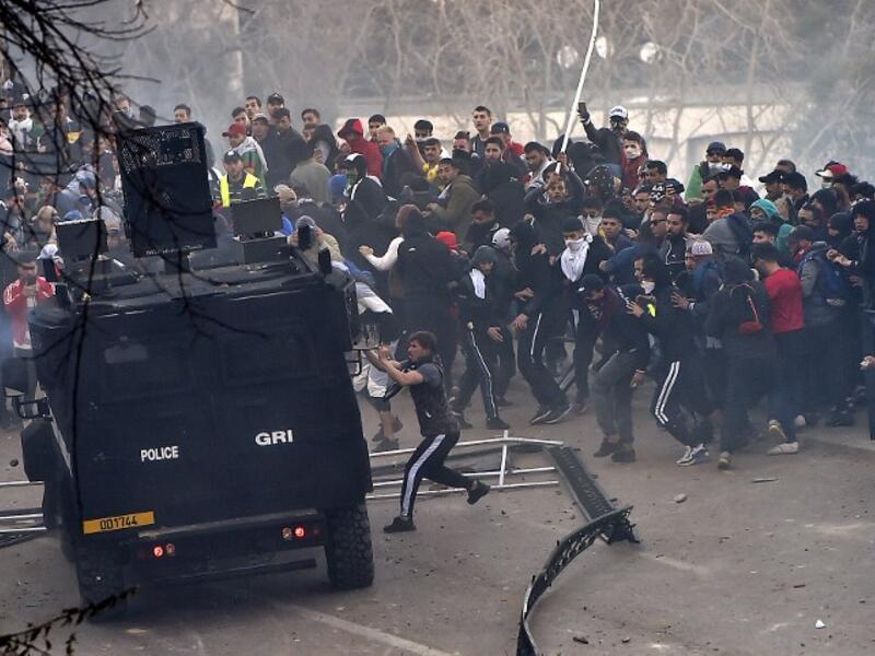 Algerian protesters attempt to overturn a riot police vehicle during clashes in the capital 
RYAD KRAMDI / AFP