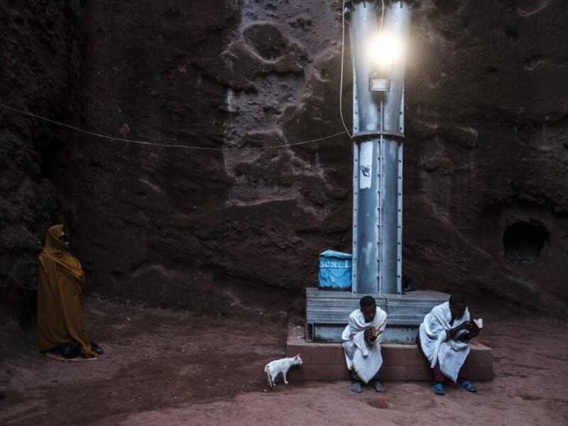 Ethiopian Orthodox devotees sit on a pillar of the shelter that protects from erosion the structure of the rock-hewn church of Saint Emmanuel in Lalibela, Ethiopia
EDUARDO SOTERAS / AFP