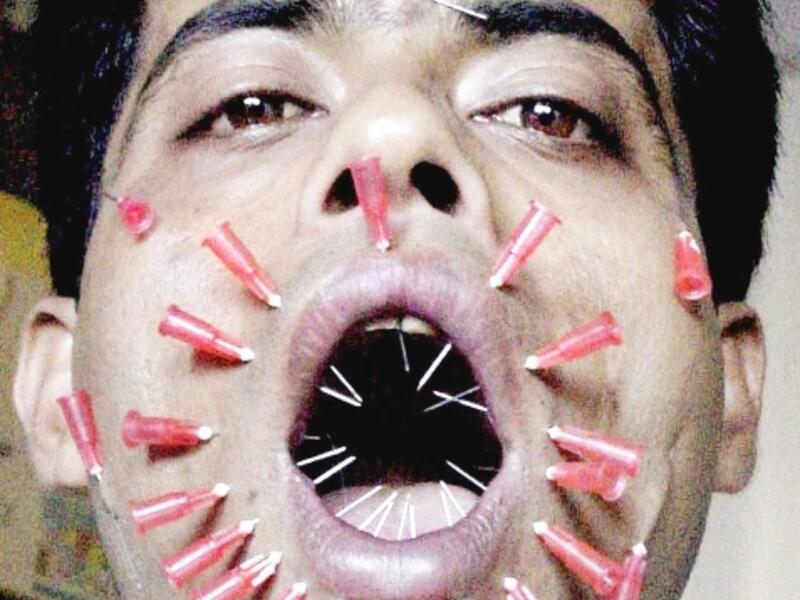 Patesh Talukdar, from Assam state, pierces his face with 23 needles during an attempt to make it into the annals of the Guinness Book of World Records November 11, 2002 in Guwahati. Talukdar has already made it into the Limca book of records with his bizarre feat of consuming bulbs and bricks. (AFP Photo)