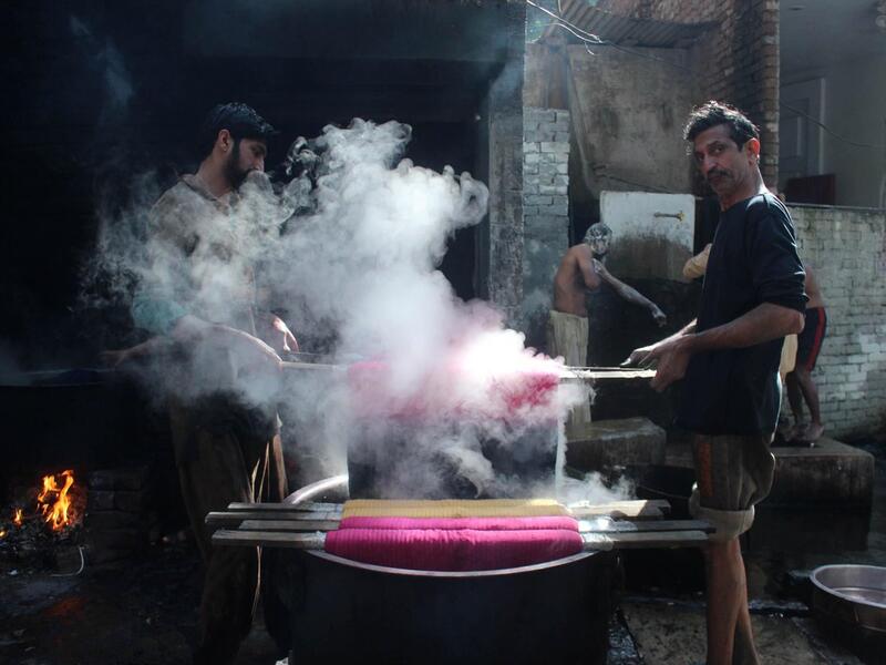 Pakistani workers dye fabric threads at a factory in Lahore (Twitter)