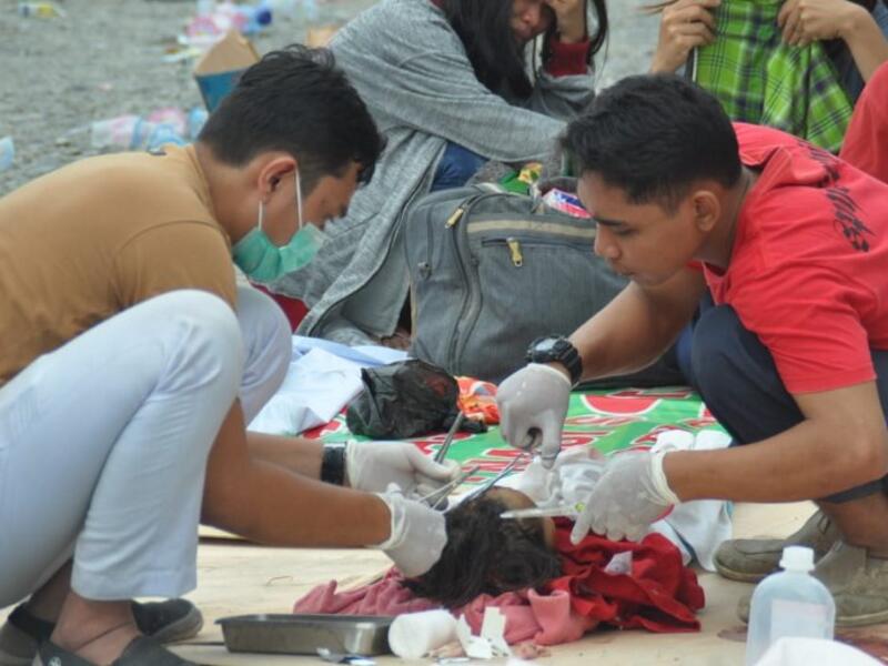 Medical team members help patients outside a hospital after an earthquake and a tsunami hit Palu, on Sulawesi island on September 29, 2018. (MUHAMMAD RIFKI / AFP) 