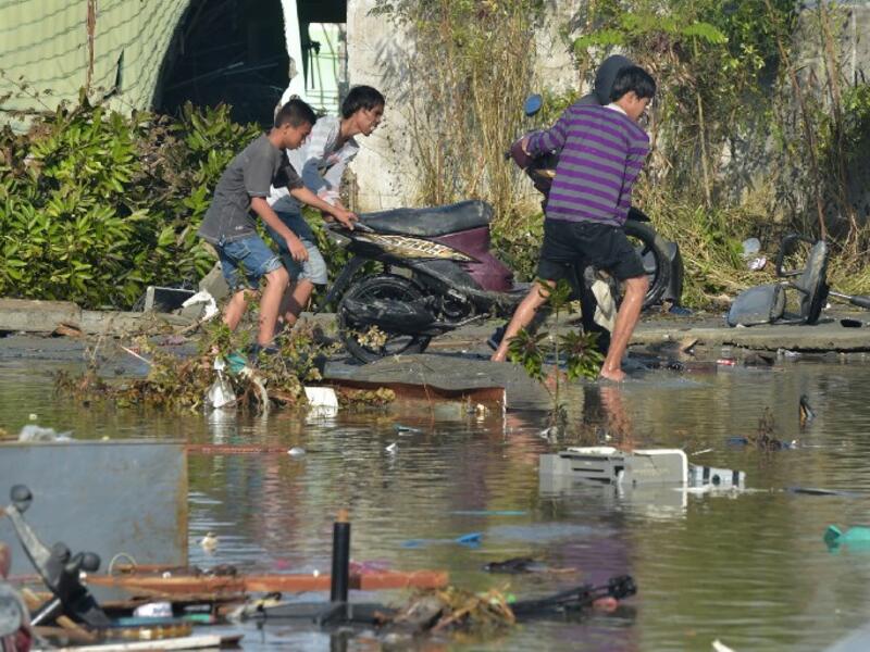 People salvage a motorcyle in Palu, Indonesia's Central Sulawesi on September 30, 2018, following the September 28 earthquake and tsunami.(ADEK BERRY / AFP)