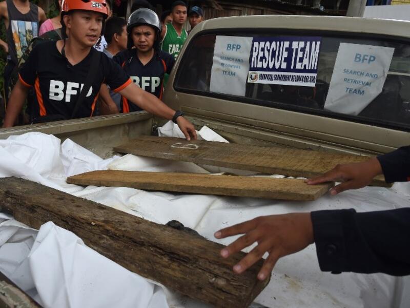 Rescue personnel remove weights securing a tarp over a vehicle transporting the corpses of dead civilians retrieved near the frontline in the outskirts of Marawi on the southern island of Mindanao on June 28, 2017. (Ted Aljibe/AFP)