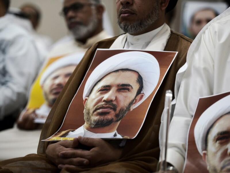 A Bahraini man holds a placard bearing the portrait of Sheikh Ali Salman, head of the Shia opposition movement Al-Wefaq, during a protest against his arrest outside Manama. (AFP/Mohammed al-Shaikh)