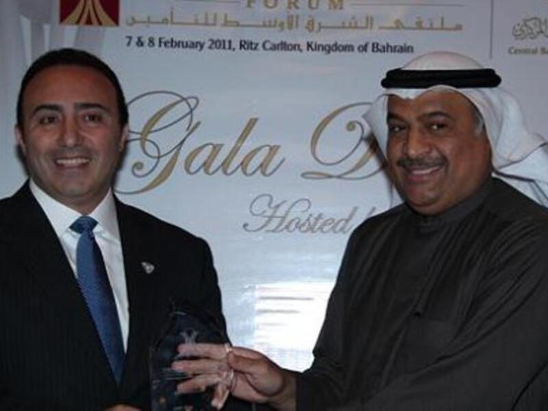 Abdul Rahman Mohammed Al Baker, Executive Director of Financial Institutions Supervision at the Central Bank of Bahrain, presenting the award to Walid Sidani, CEO of ADNIC