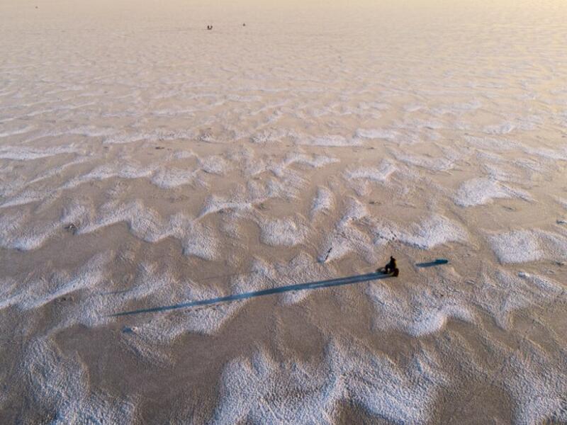 An aerial view shows a man sitting waiting near a hole drilled into the frozen sea as he ice fishes on the Gulf of Bothnia, near Vaasa, Western Finland on December 28, 2018, where winter daylight last for some four hours. 
Olivier MORIN / AFP