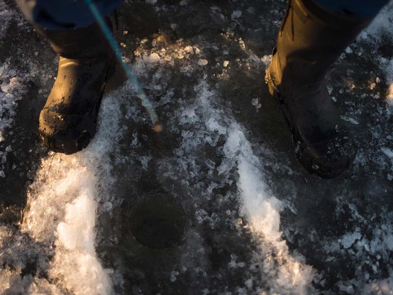 A man is ice-fishing at midday on the frozen Bothnia Sea, on December 28, 2016 in Vaasa, Western Finland. (OLIVIER MORIN/AFP)
