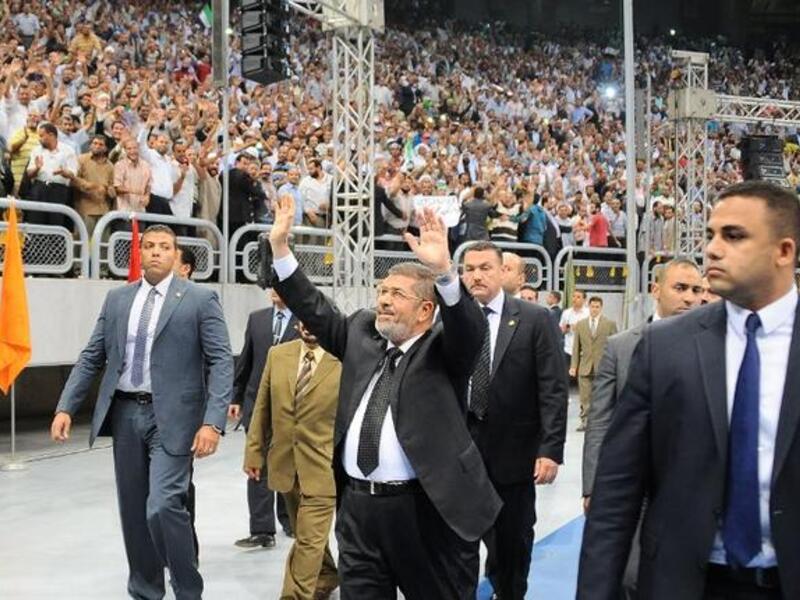Egyptian President Mohammed Morsi (C) waves at thousands of Islamist supporters as he arrives for the "Support for Syria" rally at a Cairo stadium on June 15 (Egyptian Presidency / AFP)