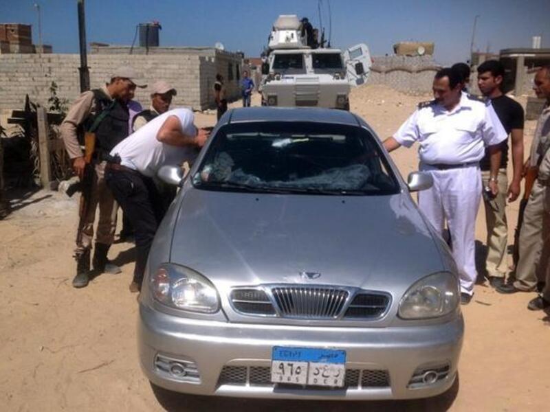 A picture taken on July 6, shows Egyptian policemen inspecting the car of a Coptic Christian priest killed in al-Arish north of the Sinai peninsula (AFP)