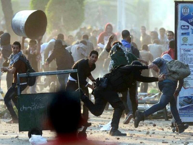 An Egyptian policeman tries to detain a student of Cairo University who support the Muslim Brotherhood during clashes with riot police in Cairo. [AFP]