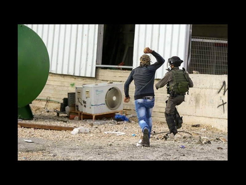 palestinian chases israeli soldier with stone