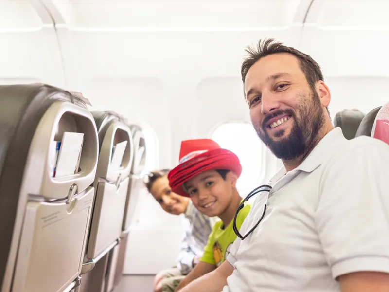 Arab man and kids plane seats looking up