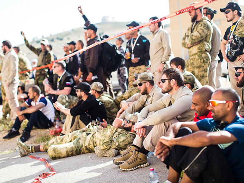 Teams from various countries relax together and cheer on their teammates during the first event of the Warrior Competition, "Top Gun." Here, it’s normal to see soldiers from Chechnya, Afghanistan, Brunei, and Canada chatting together.

