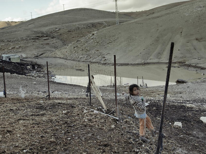 tiny Palestinian girl at the security fence
