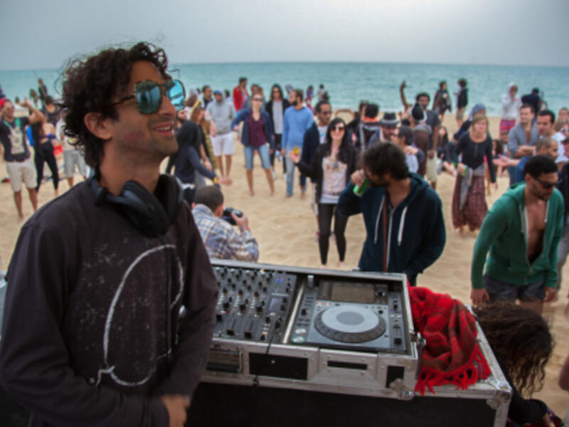 DJ Nickodemus from New York City, performing at Kite Loop beach during Oshtoora music festival in 2015. (Majawadin.files.wordpress.com)