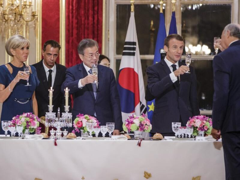 French President Emmanuel Macron (C-R), his wife Brigitte Macron (L) and South Korean President Moon Jae-in (C-L) toast during a state dinner at the Elysee Presidential palace in Paris, on October 15, 2018. 
(Christophe Petit-Tesson / POOL / AFP)
