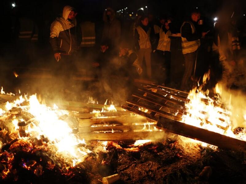 People block the Caen's circular road on November 18, 2018 in Caen, northwestern France, on a second day of action after a nationwide popular initiated day of protest called "yellow vest"  against fuel prices.
CHARLY TRIBALLEAU / AFP