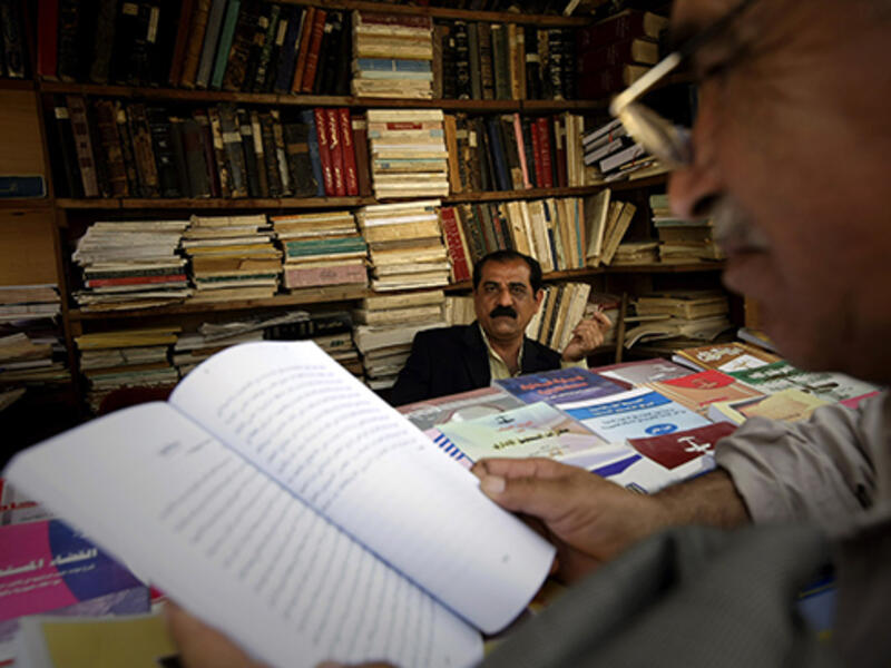 A customer browses books in a shop on Mutanabi Street, famed as Baghdad's bookselling district.  A scarcity of science literature available in Iraq inspired the Real Sciences group to translate works into Arabic.  (AFP/Joseph Eid)