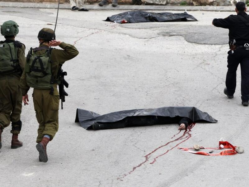 IDF soldiers surround the body of al-Sharif after he was shot and killed. (AFP/Hazem Bader)