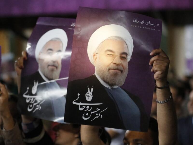 Supporters of Iranian presidential candidate Hassan Rouhani hold his portrait during a campaign rally in the capital Tehran on May 4, 2017. (AFP/Atta Kenare)