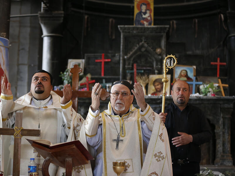 Iraqi clergy celebrate Palm Sunday in a church in Qaraqosh, near Mosul, 9 April 2017. (AFP/Ahmad Gharabli)
