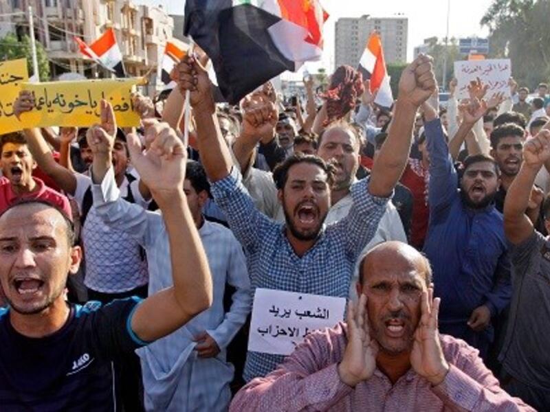 Iraqis shout slogans during a protest in Najaf.  (AFP/ File Photo)