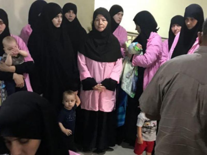 Baghdad's Central Criminal Court shows women who have been sentenced to life in prison on grounds of joining ISIS standing with their children in a hallway. (Ammar Karim / AFP)