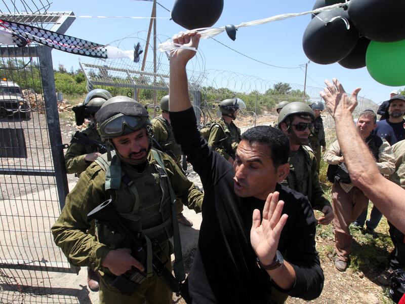 Palestinian protesters are stopped by Israeli soldiers during a protest against settlement expansion on Palestinian land. [vosizneias]