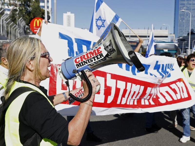 An Israeli protester wearing a yellow vest uses a loudspeaker to shout slogans during demonstrations against the rising cost of living on December 14, 2018.
JACK GUEZ / AFP