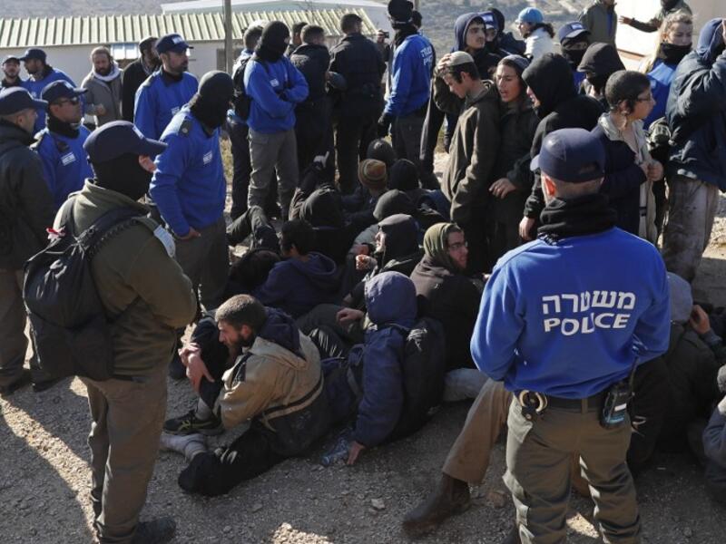 Israeli police guard Israeli settlers on the second day of an Israeli police operation to evict the hardline occupants and their supporters from the West Bank settler outpost of Amona on February 2, 2017. (AFP/Thomas Coex)